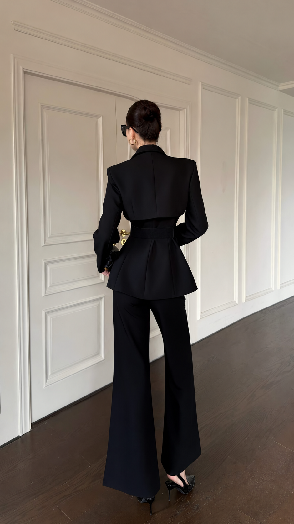 Back view of black structured blazer and wide-leg trousers with fitted waist detail