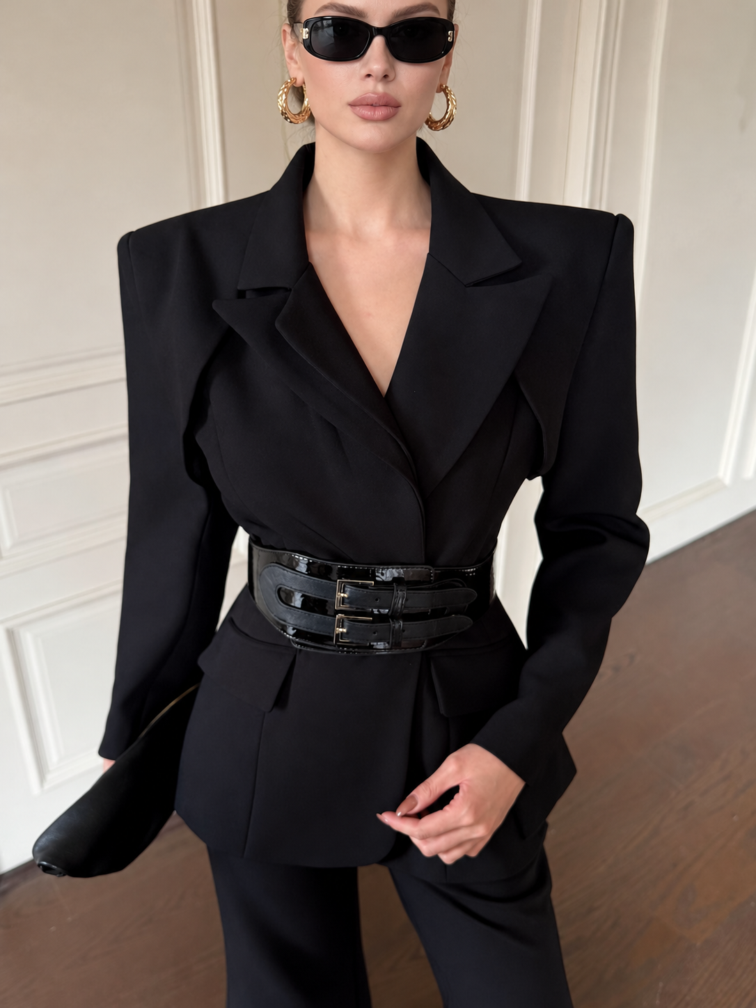 Close-up of black blazer co-ord with notched lapels and double-buckle waist belt
