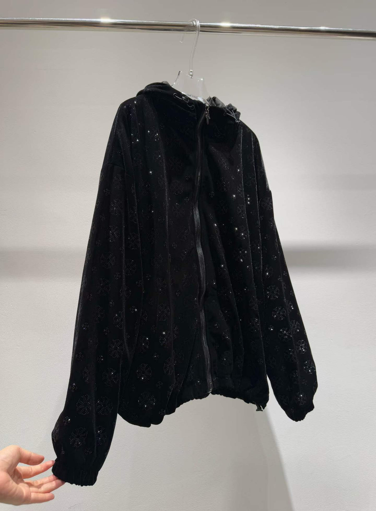 Black floral sparkle hooded zip-front jacket, angled front