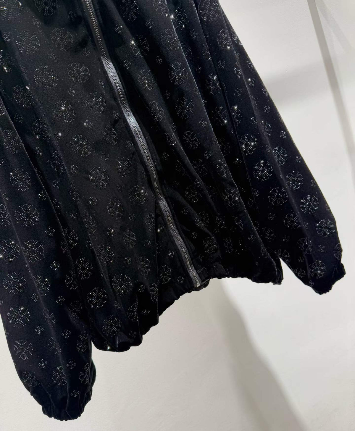 Black floral sparkle hooded zip-front jacket, hem detail