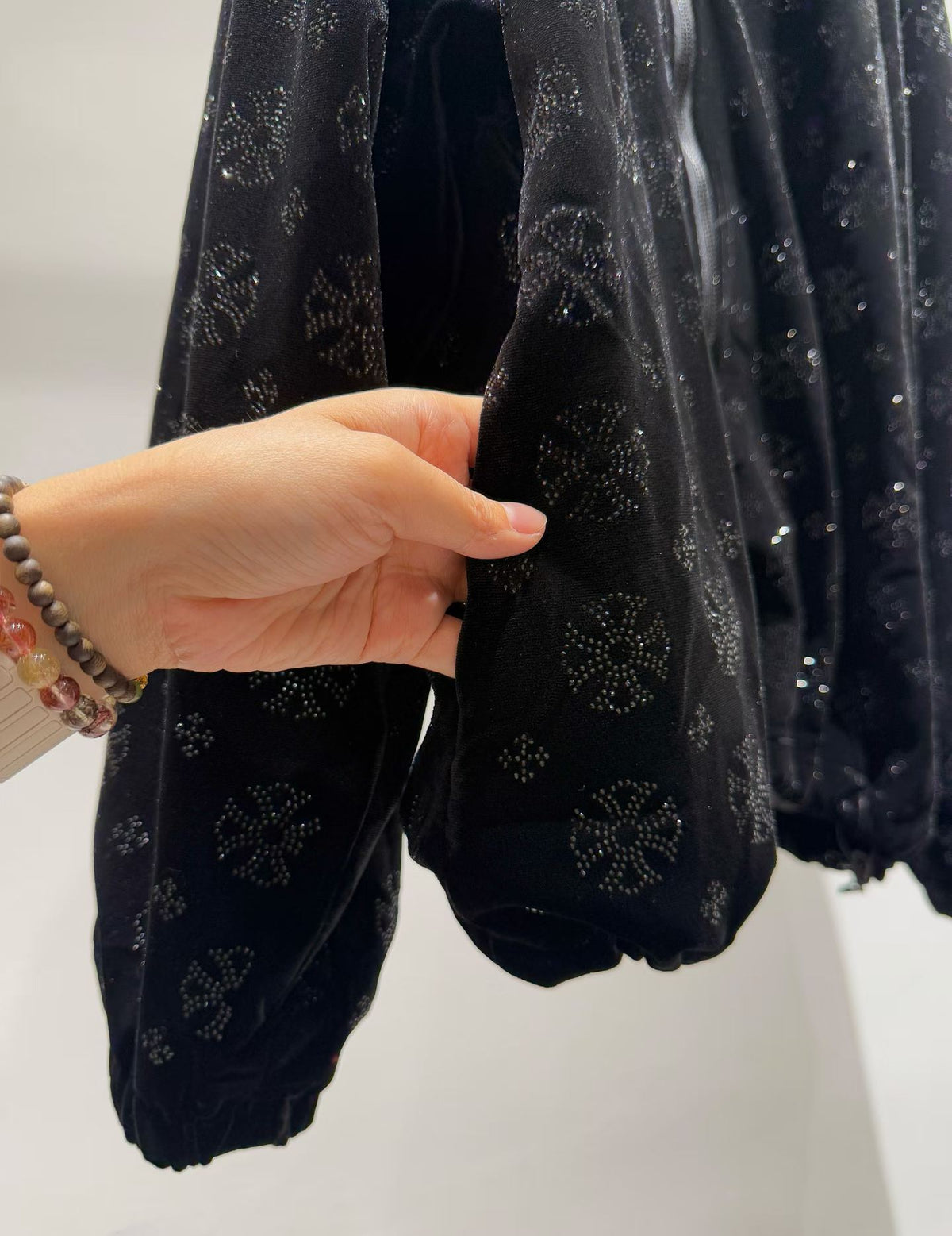 Black floral sparkle hooded zip-front jacket, sleeve detail