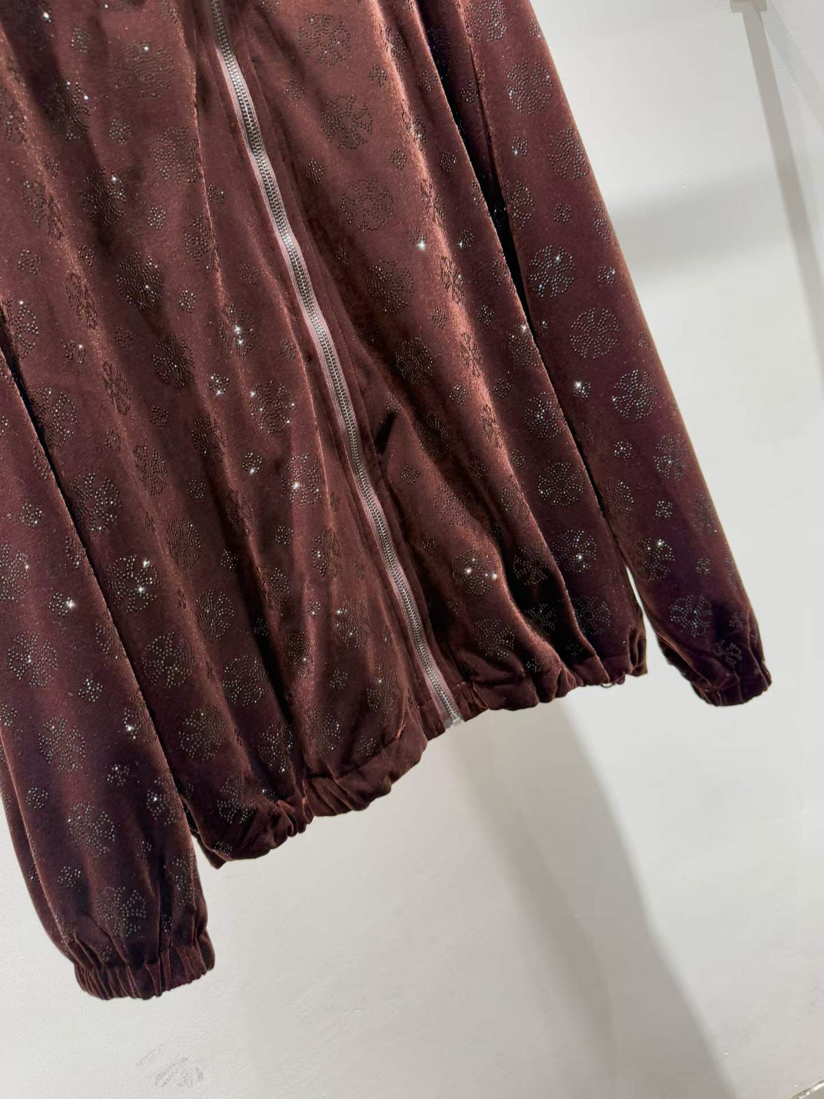 Brown floral sparkle hooded zip-front jacket, hem detail