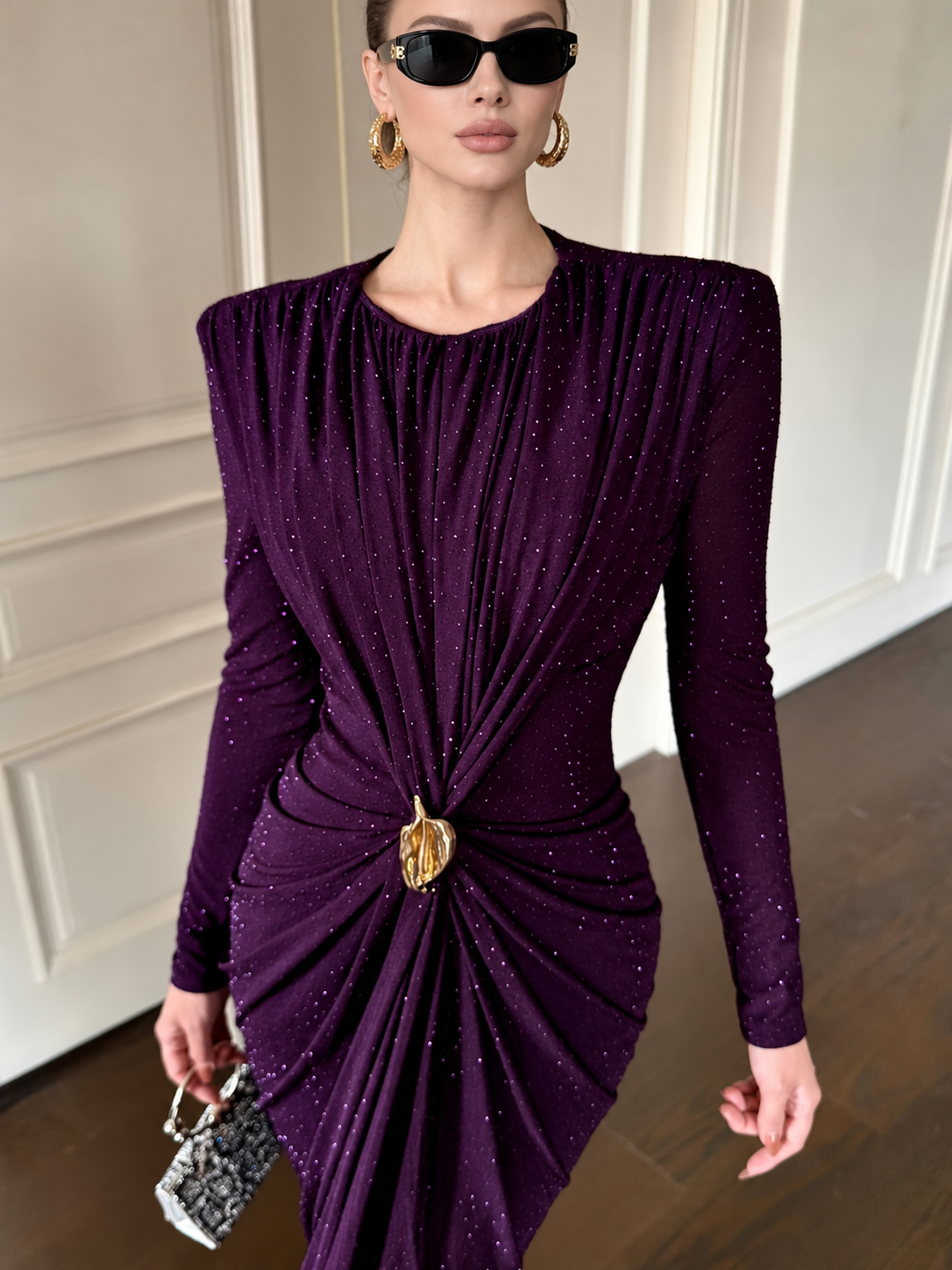 Close-up of the plum ruched dress with subtle sparkle and a gold-tone waist accent
