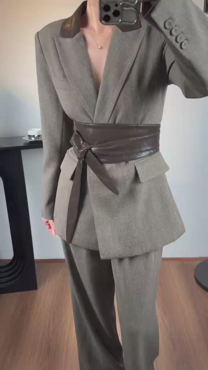 Elegantwom gray tailored blazer and wide-leg pants set video showing a woman wearing the structured grey suit with a contrast brown wrap belt and notched lapel.