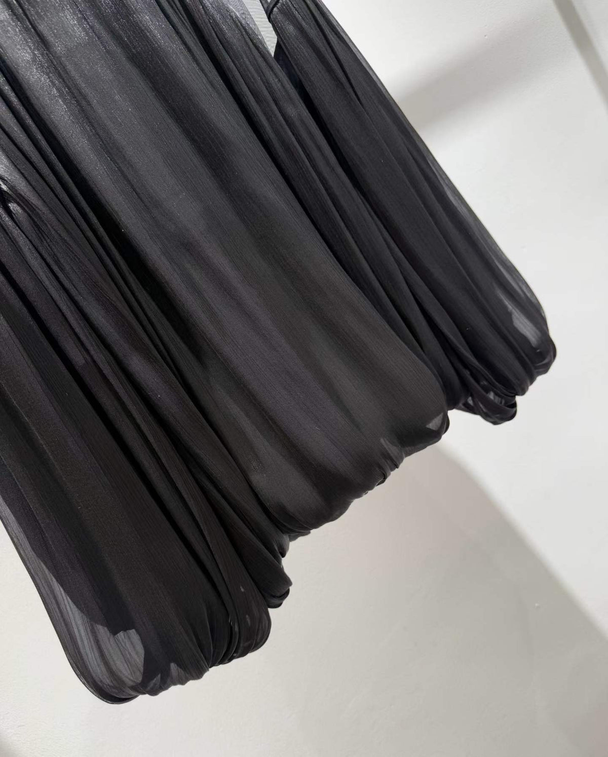 Black blouse pleated fabric and bubble hem close-up