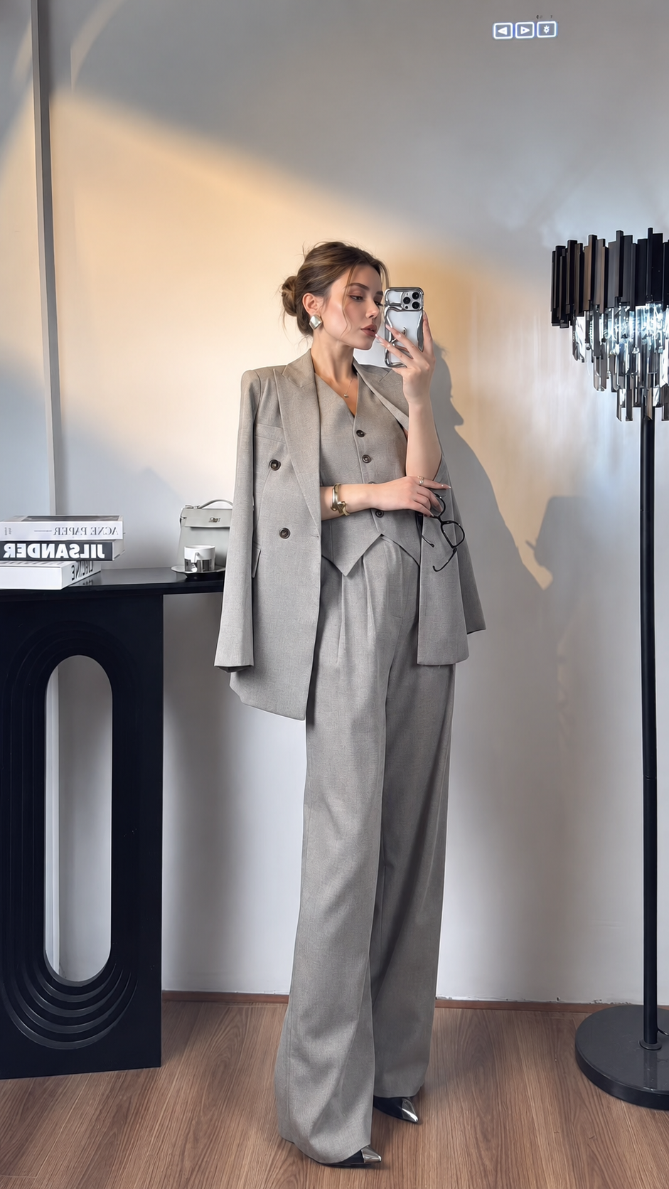 Women's light gray three-piece suit with blazer draped over the shoulders